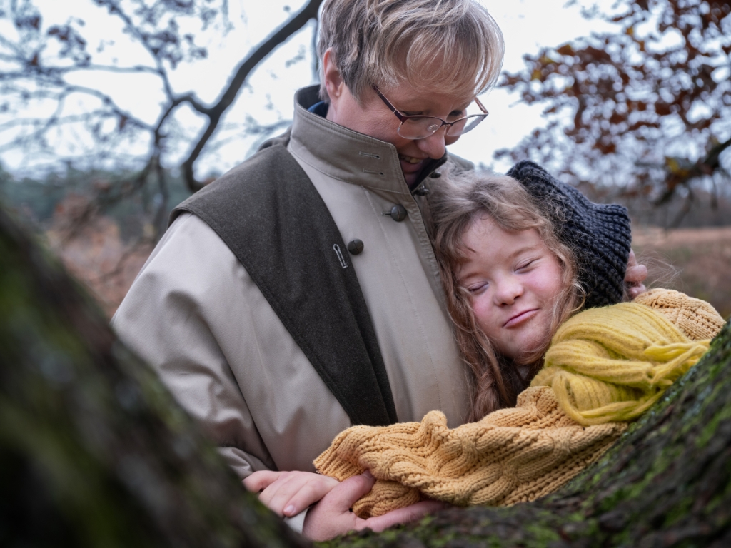 Mamma kramar om dotter med Downs syndrom en mulen höstdag. 