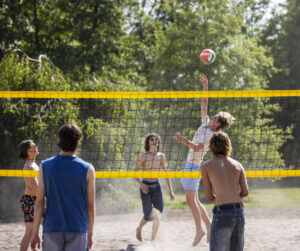 Killar i shorts som spelar beachvolleyboll