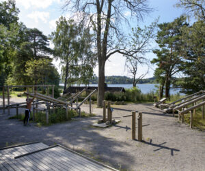 Utegym beläget vid sjö. redskap i trä. 