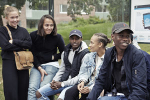 Ungdomar sitter tillsammasn och väntar på¨buss