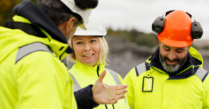 Personer i gula arbetskläder och hjälmar