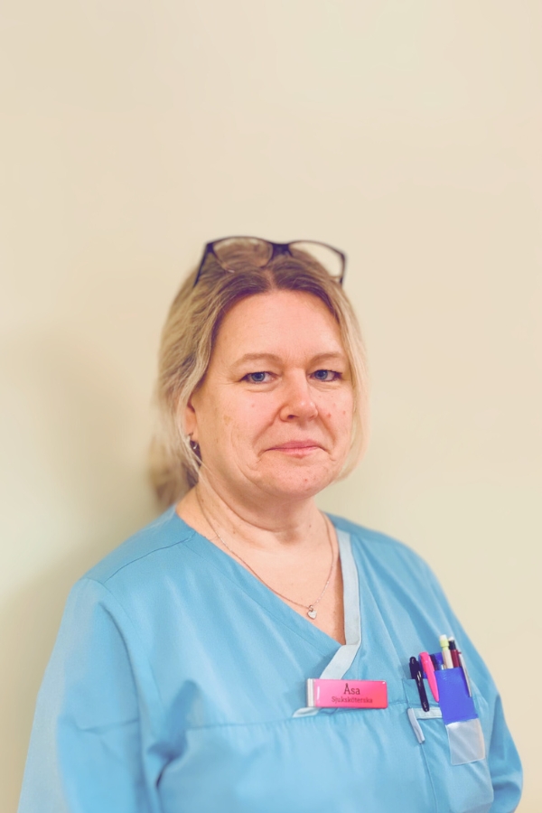 Sjuksköterska Åsa Samuelsson i blå arbetskläder och glasögon på huvudet.